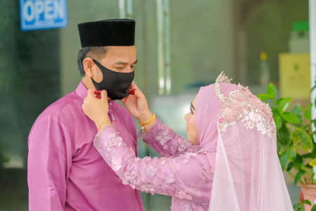 Muadzam Shah, Malaysia - May 9th,  2020 : A muslim couple getting solemnization  in medical face masks during coronavirus pandemic. COVID-19 weddings.のeditorial素材