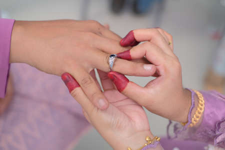 Malay wedding couple putting a ring on hand.Selective focus and shallow DOF.のeditorial素材
