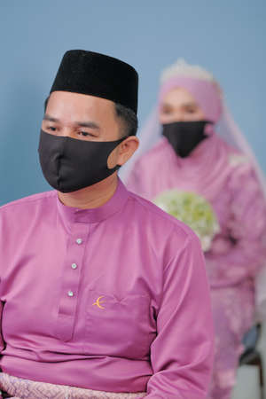 Muadzam Shah, Malaysia - May 9th,  2020 : A muslim couple getting solemnization  in medical face masks during coronavirus pandemic. COVID-19 weddings.のeditorial素材