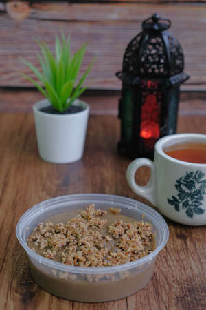 Traditional cookies in Malaysia during Hari Raya Festival known as Kuih Kole Kacang with lantern and tea  on the wooden backgroundの写真素材