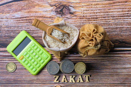 Coin ,calculator ,  and rice  on wooden background. Top view. Flat lay.  Zakat Concept.
