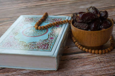 Quran Kareem , wooden rosary , SAFAWI  dates on wooden backgroundの写真素材