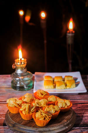 Closeup of traditional snack during Hari Raya Aidilfitri in Malaysia called kuih tart or pineapple tart and honey cornflakes  with vintage oil lamp at night.の写真素材