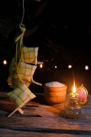 Close-up of oil lamp and ketupats against black backgroundの写真素材