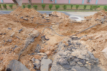 Electric cable repair, open trench with damaged cable on its bottom .