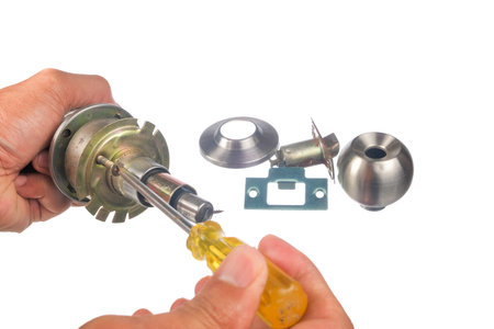 Man using  screw driver . The closeup of worker hands assembling door knob isolated on white...