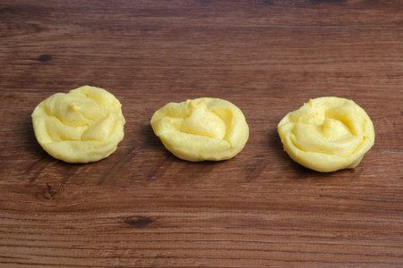 Cream puff cakes with custard on the wooden plate