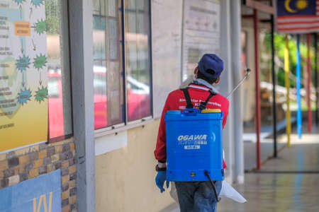 Muadzam Shah-Malaysia - June 22th, 2020 : Disinfectant worker in protective suit making disinfection in the college  to control an outbreak of coronavirus .のeditorial素材