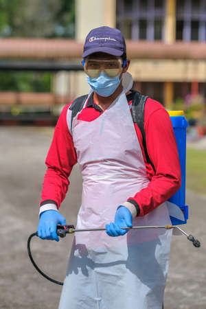 Muadzam Shah-Malaysia - June 22th, 2020 : Disinfectant worker in protective suit making disinfection in the college  to control an outbreak of coronavirus .のeditorial素材