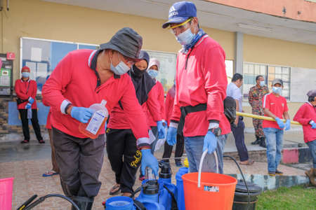 Muadzam Shah-Malaysia - June 22th, 2020 : Workers   in protective suit with gloves adding disinfectant and mixing chemicals in tank reservoir to start disinfecting against  COVID-19のeditorial素材