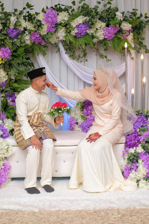 Bride and groom pose during Malay wedding celebration in Malaysiaの写真素材