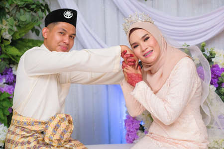 Bride and groom pose during Malay wedding celebration in Malaysiaの写真素材
