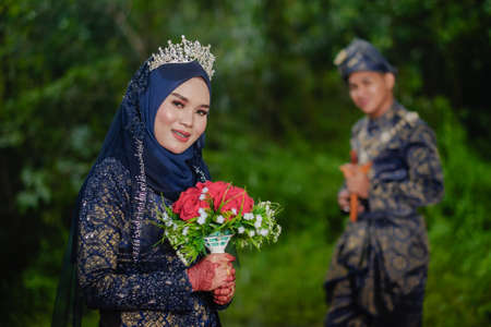 Creative outdoor photo shoot  with lighting of a Malay loving couple bride and groom on their wedding wearing a traditional Malay dressの写真素材