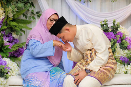 Muadzam Shah, Malaysia -  June 18th,  2020 :  Indoor shooting for Malay wedding. The  bride and groom  posing with their family.  Happy & Family Concept.のeditorial素材