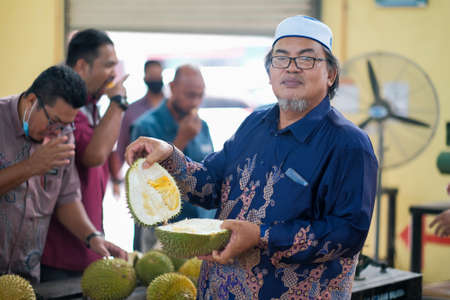 Muadzam Shah, Malaysia - June 25th,2020:  Happy asian men enjoy eating durian fruit with thier friends.のeditorial素材