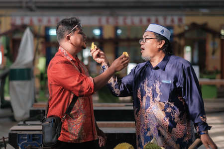 Muadzam Shah, Malaysia - June 25th,2020:  Happy asian men enjoy eating durian fruit with thier friends.のeditorial素材