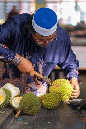 Muadzam Shah, Malaysia - June 25th,2020:  Happy asian men enjoy eating durian fruit with thier friends.のeditorial素材