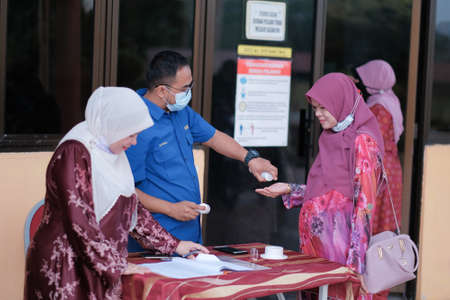 Muadzam Shah, Malaysia - June 29th, 2020: New normal, Business people team using hand sanitizer, healthcare and covid-19 prevention conceptのeditorial素材
