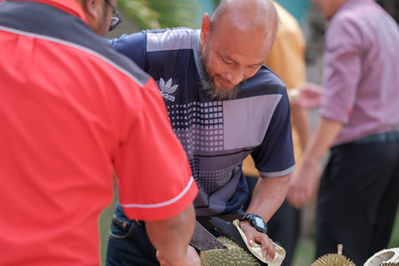 Muadzam Shah, Malaysia - July 1st ,2020:  Happy asian men enjoy eating durian fruit with thier friends.のeditorial素材