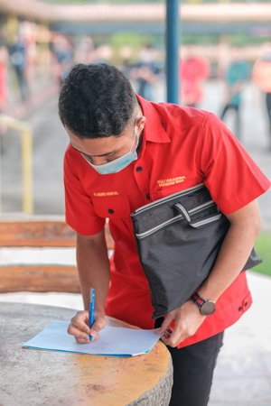 Muadzam Shah, Malaysia July 9th, 2020 : Teacher using thermometer temperature screening student for...