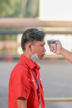 Muadzam Shah, Malaysia - July 7th, 2020 : Teacher using thermometer temperature screening student for fever against the spread of COVID-19 while student coming back to school, Education concept.のeditorial素材