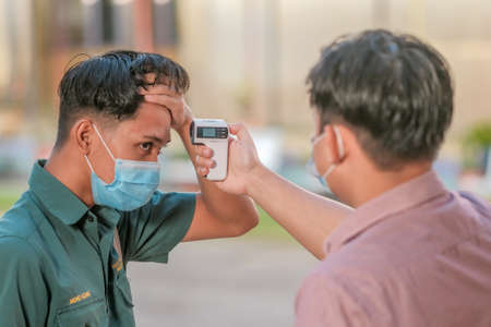 Muadzam Shah, Malaysia - July 7th, 2020 : Teacher using thermometer temperature screening student for fever against the spread of COVID-19 while student coming back to school, Education concept.のeditorial素材