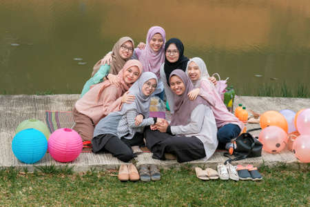 Photo of happy schoolmates or reunion, have picnic together during sunny day and  have pleasant talk. Togetherness and lifestyle conceptのeditorial素材