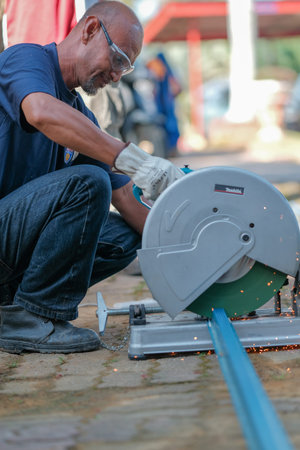Muadzam Shah, Malaysia - July 9th,2020:  Man white glove and goggle using disc cutter  to cut c...