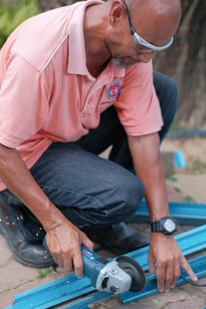 Muadzam Shah, Malaysia - July 16th,2020:  Man using disc cutter  to cut C shape channel , tools for...