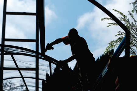 Muadzam Shah, Malaysia - July 15th , 2020 : Construction engineer an electric drill and screw tools to fasten down metal roofing work for roof industrial concept.のeditorial素材
