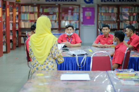 Muadzam Shah, Malaysia _ August 12th, 2020: Teacher and students studying in the library together