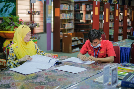 Muadzam Shah, Malaysia _ August 12th, 2020: Teacher and students studying in the library together