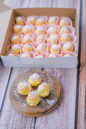 Cream puff cakes with custard on wooden backgroundの写真素材