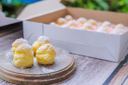 Cream puff cakes with custard on wooden backgroundの写真素材