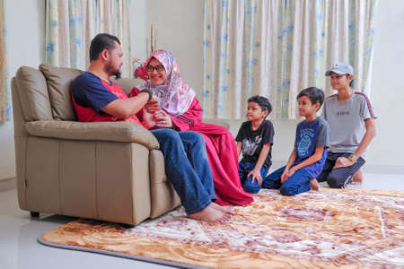 Muadzam Shah, Malaysia - June 21st, 2020 :  Wife asking her husband for forgiveness as part of the the Islamic celebration of Hari Raya Aidilfitri (Eid al-Fitr).のeditorial素材