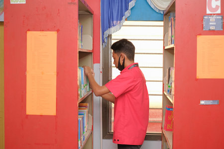 Muadzam Shah, Malaysia - August 12th, 2020 :  Male college student reaching for a library book.