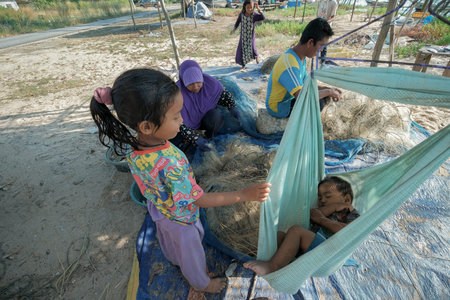 Kuala Rompin, Malaysia- August 30th,2020 : Traditional Malay  fisherman lifting net into the  boat...