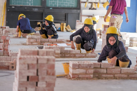 Besut, Malaysia - September 8th, 2020 : College students  working brick wall construction in...