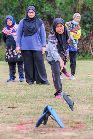 Muadzam Shah, Malaysia -   September 16th, 2020 : People playing traditional games called  slipper throwing game  at the field during Malaysia Dayのeditorial素材
