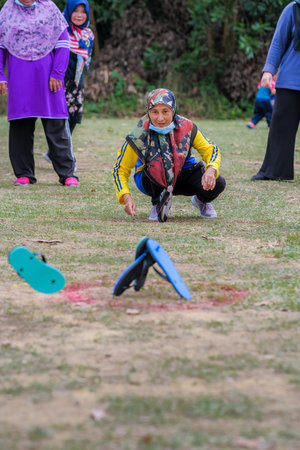 Muadzam Shah, Malaysia -   September 16th, 2020 : People playing traditional games called  slipper throwing game  at the field during Malaysia Dayのeditorial素材