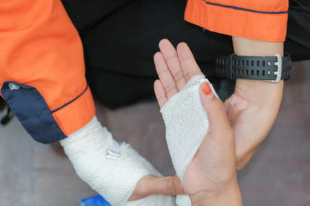 Student first aid training in the hall. Student trying to splint the hand  of a patient's broken hand incident with elastic bandage in college.のeditorial素材