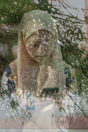 Portrait of happy muslim woman using mobile phone while standing  in the college