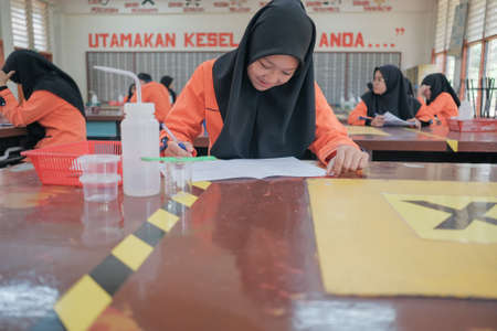 Muadzam Shah, Malaysia - October 5th, 2020 :  Young college student in chemistry class, writing notes. Focused student in classroom. .Education conceptのeditorial素材