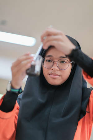Muadzam Shah, Malaysia - October 5th, 2020 : Asian students learning and doing a chemical experiment  in science class on the table.Education conceptのeditorial素材