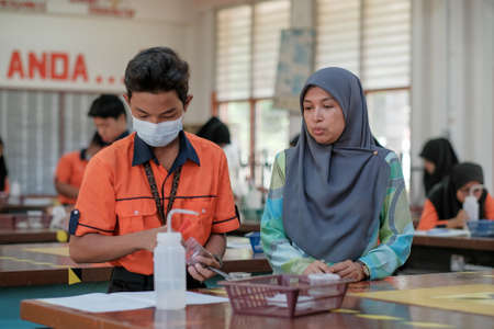 Muadzam Shah, Malaysia - October 5th, 2020 :  Teacher  and Asian  students learning and doing a chemical experiment in the experiment laboratory class at school.Education conceptのeditorial素材