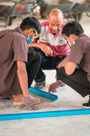 Muadzam Shah, Malaysia - July 8th,2020: Students and instructor  making metal roof frame in industrial workshop.のeditorial素材