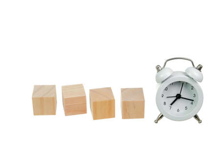 Wooden block house and white alarm clock. Concept of time management, success and leadership.の写真素材