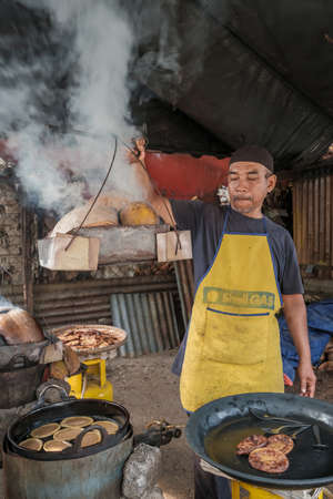 Kota Bharu, Malaysia - July 30th, 2020 : The portrait of husband and wife  making a local Malaysian desert called Akok Kedut using   coconut husks for fuel.のeditorial素材