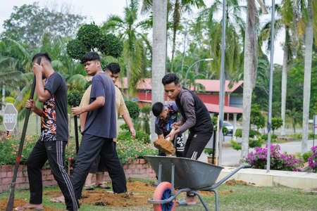 Muadzam Shah, Malaysia - October 14th,2020:  Workers digging hole for stump concrete foundation holderのeditorial素材
