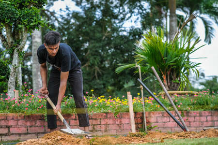 Muadzam Shah, Malaysia - October 14th,2020:  Workers digging hole for stump concrete foundation holderのeditorial素材